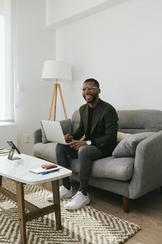 a man sitting on a couch using a laptop computer