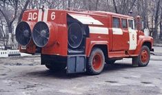 an old red fire truck parked in a parking lot