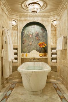 a bath room with a large tub and a chandelier