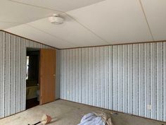 an empty room that has been painted white with vertical striped wallpaper on the walls