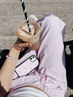 a person laying on the ground with a drink in their hand and a straw sticking out of it