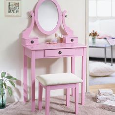 a pink vanity table with a mirror and stool