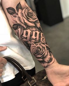 a woman's arm with roses and the word aro tattooed on it