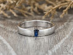 a wedding ring with a blue stone in the center