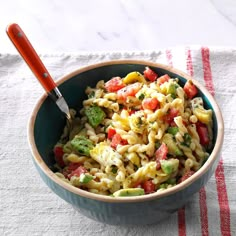 a bowl filled with pasta and veggies on top of a white table cloth