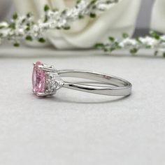 This beautiful ring is made from genuine 925 sterling silver with rhodium plating. Ring details- -The Main stone is an oval cut 8mm by 6mm Pink Simulated Diamond -Side stones are 1.5 Round simulated diamonds -Ring is casted in solid 925 sterling silver with rhodium plating (yellow gold and rose gold plated also available, please check the drop down menu for more options) -The Total face height of the ring measures 8mms and the band width measures 2mms -Each ring is handmade and made to order, so Classic Pink Ring With Polished Finish, Silver Cushion Cut Ring With Polished Finish, Oval Pink Promise Ring, Pink Oval Promise Ring, Oval Brilliant Cut Birthstone Ring For Promise, Pink Wedding Rings With Polished Finish, Oval Brilliant Cut Sterling Silver Birthstone Ring, Silver Solitaire Ring With Oval Shape, Oval Polished Finish Halo Ring For A Gift