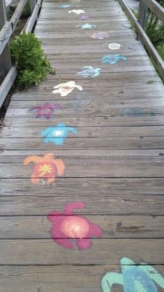 a wooden walkway with colorful drawings on it