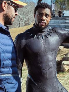 two men in wetsuits standing next to each other