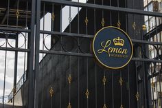 the entrance to lenon workspace with an iron gate and crown logo on it