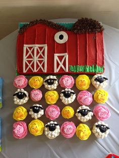 cupcakes are arranged in the shape of farm animals on a table with a red barn