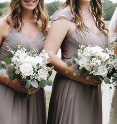 three bridesmaids are holding bouquets in their hands