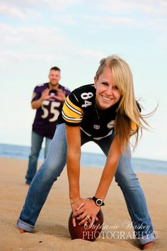 two people are posing on the beach with a football