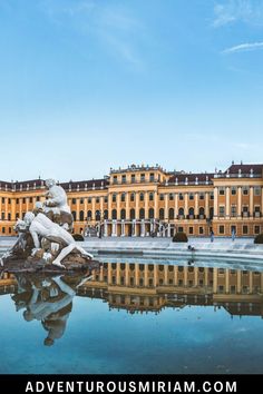 a statue is in the middle of a pond and buildings are in the back ground