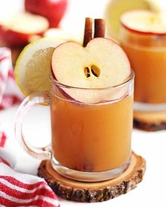 two mugs filled with apple cider and cinnamon sticks