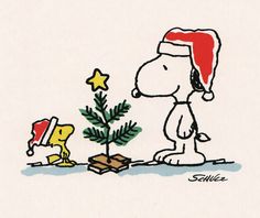 a charlie brown christmas card with a tree and a dog on the ground next to it