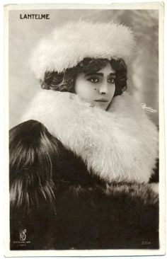 an old black and white photo of a woman wearing a fur hat