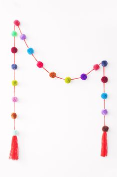 multicolored pom - pom garland with tassels on white background