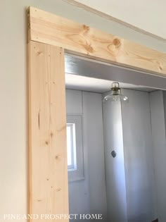 an unfinished mirror frame in the corner of a room with white walls and wood trim