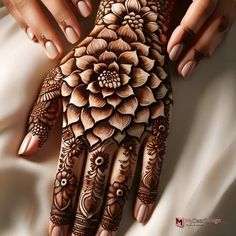 a woman's hand with henna tattoos on it and flowers painted on the palm