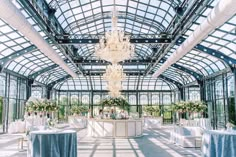 the inside of a building with tables, chairs and chandeliers on it's ceiling