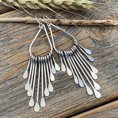 Silver Teardrop Boho Fan Earrings: These silver fan paddle earrings are the perfect mix of geometric & boho and will compliment any outfit! Graduated hammered paddles hang from a beautifully crafted teardrop focal point. These earrings are handcrafted from silver plated jewelers grade brass. They are approximately 2.75 inches in length and .62 inches at the widest portion. To view more of my original jewelry designs, visit: https://www.etsy.com/shop/TheBeadCounter Modern Silver Teardrop Chandelier Earrings, Bohemian Long Drop Teardrop Earrings, Bohemian Teardrop Long Drop Earrings, Modern Nickel-free Dangle Teardrop Earrings, Nickel Free Long Drop Teardrop Earrings, Nickel-free Long Drop Teardrop Earrings, Bohemian Teardrop Sterling Silver Chandelier Earrings, Bohemian Sterling Silver Teardrop Chandelier Earrings, Silver Teardrop Chandelier Earrings