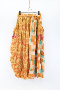 Feel fabulous in this fun skirt! Wear the hem down or cinch it up for a different look. The Festival Maxi Skirt is crafted from vintage kantha embroidered saris and features a comfortable elastic waistband, dropped pouch pockets and cinch-tie detail at the hem. Our beautiful maxi skirt is perfect for dressing up or down. Available in two sizes-(Recommended) S 4-10 L 12-18 Approximately 38” long Care Instructions: Hand wash and line dry for longest life. Disclaimer: The material used in this styl Bohemian Cotton Harem Skirt, Traditional Multicolor Harem Pants For Summer, Traditional Block Print Bottoms For Summer, Traditional Skirt With Elastic Waistband For Spring, Orange Bohemian Skirt With Elastic Waistband, Bohemian Orange Skirt With Elastic Waistband, Hippie Festival Gathered Skirt Bottoms, Hippie Festival Bottoms With Gathered Skirt, Festive Bohemian Multicolor Bottoms