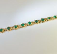 An opulent estate mint condition circa 1980 fine emerald and diamond bracelet in solid 14K yellow gold. This divine high carat luxurious bracelet is of exceptional quality. The gorgeous design of this sinuous bracelet has alternating links each set with a large faceted emerald followed by a fine cabochon emerald each precious colored gem entirely surrounded by a border of fine white diamonds. The secure box clasp is hidden inside a diamond set link. This makes the bracelet look like an endless p Formal 14k Gold Bracelet With May Birthstone, Yellow Gold Emerald Bracelet For Formal Occasions, Formal Yellow Gold Bracelet With May Birthstone, Yellow Gold Bracelets For May Birthstone, Formal Yellow Gold Bracelets For May Birthstone, 14k Gold Bracelet For Formal Occasions With May Birthstone, Fine Jewelry Bracelet With Cabochon, Emerald Bracelets For Formal Occasions, May Birthstone, Formal Emerald Bracelets For May Birthstone