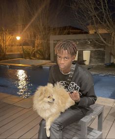 a person sitting on a bench with a dog in front of a pool at night