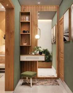 a bathroom with green walls and white flooring next to a wooden shelf filled with potted plants