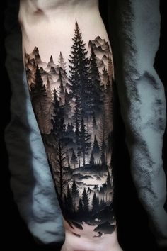 a man's arm with trees and mountains on it