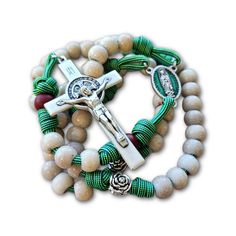 Catholics will recognize the colors in this rosary as the colors of Our Lady of Guadalupe. This is a strong but beautiful rosary that is a fitting devotion. Our Lady of Guadalupe Center medal with blue-green enamel Matching Blue-Green Shifting color military grade Paracord 3 inch tall silver Italian St. Benedict Crucifix Other optional medals may be added Tight, Even, Celtic Knotting Overall length is 23 inches and can be worn Cracked Ivory effect acrylic resin Hail Mary beads Silver Roses Our F Combat Rosary, Rugged Rosary, Paracord Rosary, Hail Mary, Rosary Bracelet, Rosary Catholic, Green Enamel, Red Bead, Sacred Heart