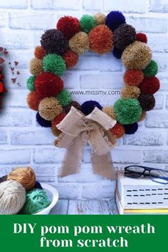 a yarn ball wreath is hanging on a brick wall