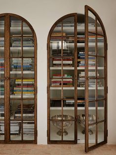 two arched glass doors with bookshelves in the middle and shelves full of books behind them