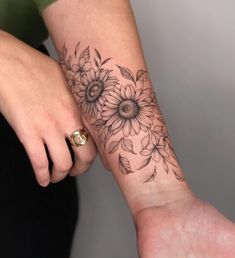 a woman's arm with a sunflower tattoo on it