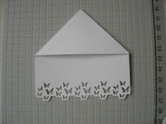 a white envelope with butterflies on it and a ruler in front of the envelope that is cut out