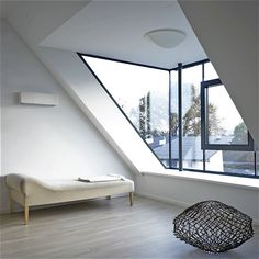 an image of a loft with skylights in the background and a bed on the floor