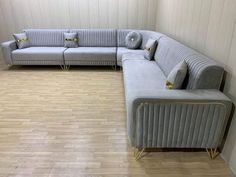 a large sectional couch sitting on top of a hard wood floor next to a wall