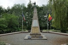 there is a monument in the middle of a park with flags flying from it's sides