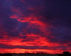 the sky is red and purple with clouds