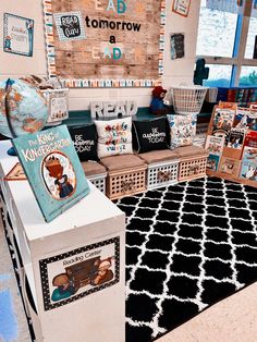 a room filled with lots of books and pictures on top of a white table next to a black and white rug