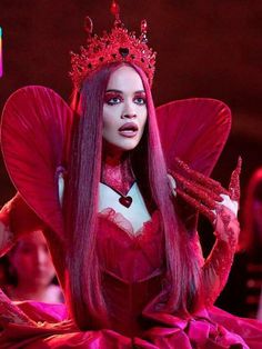 a woman with long hair wearing a red costume