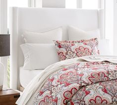 a white bed with red and blue comforter