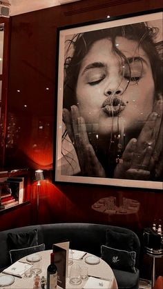 a woman's face is reflected in the window of a restaurant with round tables