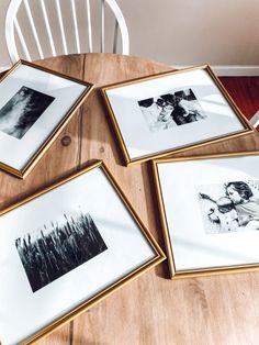 four framed pictures sitting on top of a wooden table