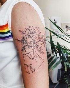 a woman's arm with a flower tattoo on the left side of her arm