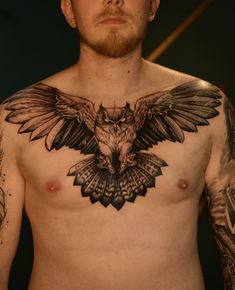 a shirtless man with tattoos on his chest and an owl tattoo on his chest