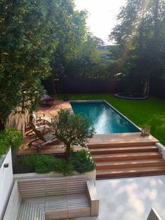 an outdoor swimming pool with steps leading up to it and trees in the back yard