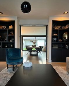 a living room filled with furniture next to a dining room table and bookshelves