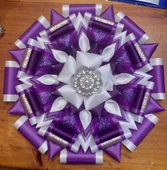 a large purple and white flower on top of a wooden table next to other items