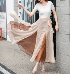 "Introducing our khaki double-layered chiffon wrap skirt. This versatile piece is perfect for adding a touch of elegance to your wardrobe. The lightweight chiffon fabric drapes beautifully, while the double-layered design adds dimension and movement. The wrap style allows for an adjustable fit. Whether you're dressing it up for a special occasion or keeping it casual with a simple top, this skirt is a must-have.  DETAILS: * Chiffon skirt * Chiffon lining * Wrap skirt * with long belt * High wais Elegant Sheer Chiffon Skirt, Flowy Beige Chiffon Skirt, Summer Sheer Flowy Maxi Skirt, Elegant Chiffon Maxi Skirt For Beach, Long Beige Chiffon Skirt, Elegant Beige Chiffon Skirt, Beige Long Chiffon Skirt, White Chiffon Maxi Skirt For Parties, Chiffon Wrap Skirt